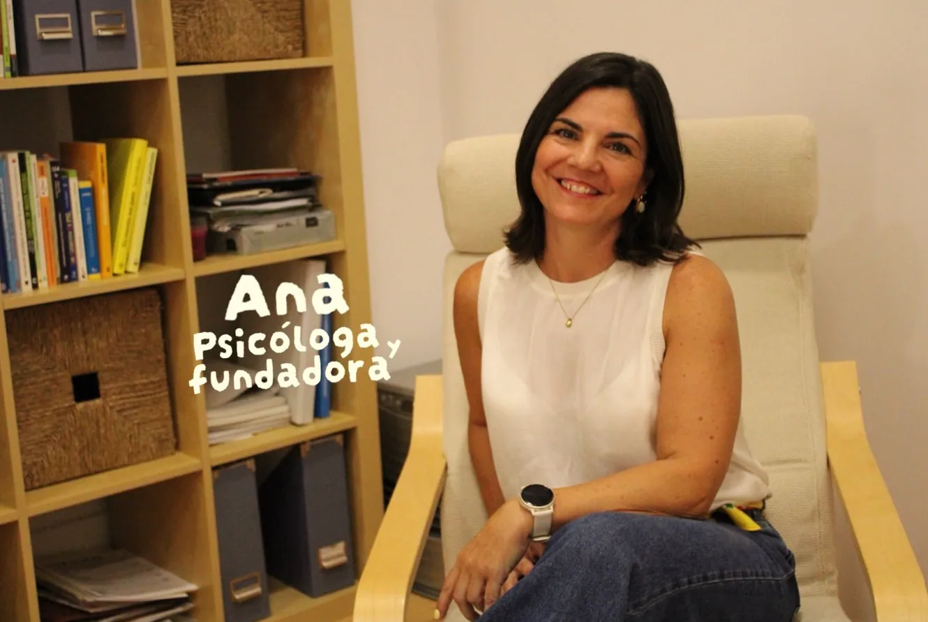 Ana, psicóloga y fundadora, sentada en un sillón de la consulta junto a una estantería de libros