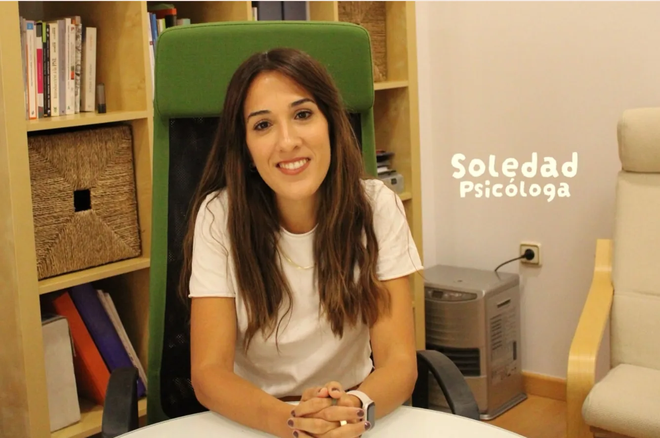 Soledad, psicóloga, sonriendo sentada a la mesa de su despacho en la consulta